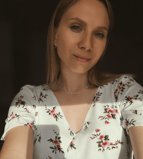 Vrouw met blond haar die een foto van zichzelf neemt, deels in de zon.